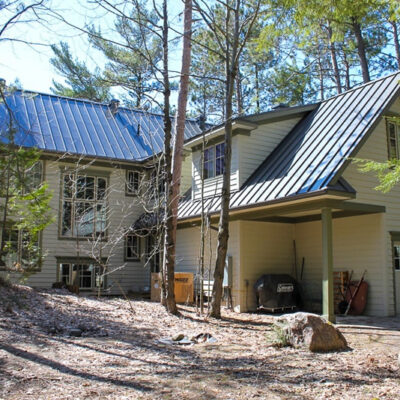 Standing seam roofing on a home in the woods.