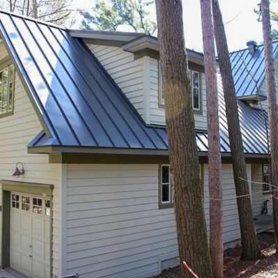 Standing seam roofing on a home in the woods.