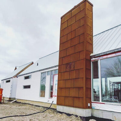 22g Corten on a 23' tall chimney wall after the natural rusting process.